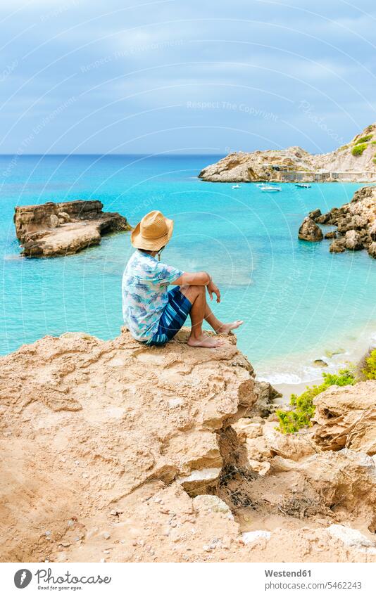 Mann sitzt auf einer Klippe und schaut aufs Meer, Ibiza, Spanien Leute Menschen People Person Personen Europäisch Kaukasier kaukasisch 1 Ein ein Mensch