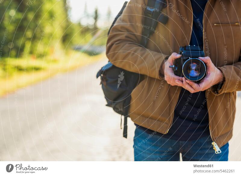 Finnland, Lappland, Nahaufnahme eines Mannes mit Kamera auf der Landstraße Fotoapparat Fotokamera Landstraßen halten Männer männlich Straße Strassen Straßen