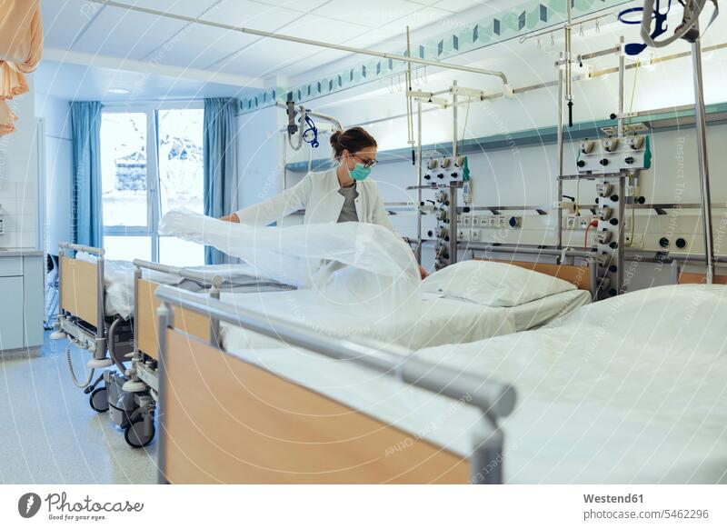 Arzt bereitet Bett im Krankenhauszimmer vor Job Berufe Berufstätigkeit Beschäftigung Jobs Betten Brillen Arbeit Gesundheit Gesundheitswesen medizinisch