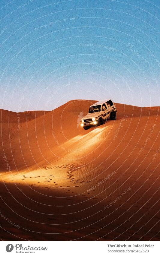 Auto fährt bei Dämmerung die Düne runter Autofahren Sand Spuren Licht Männer männerspielzeug Ferien & Urlaub & Reisen Natur Landschaft Wüste Außenaufnahme Oman