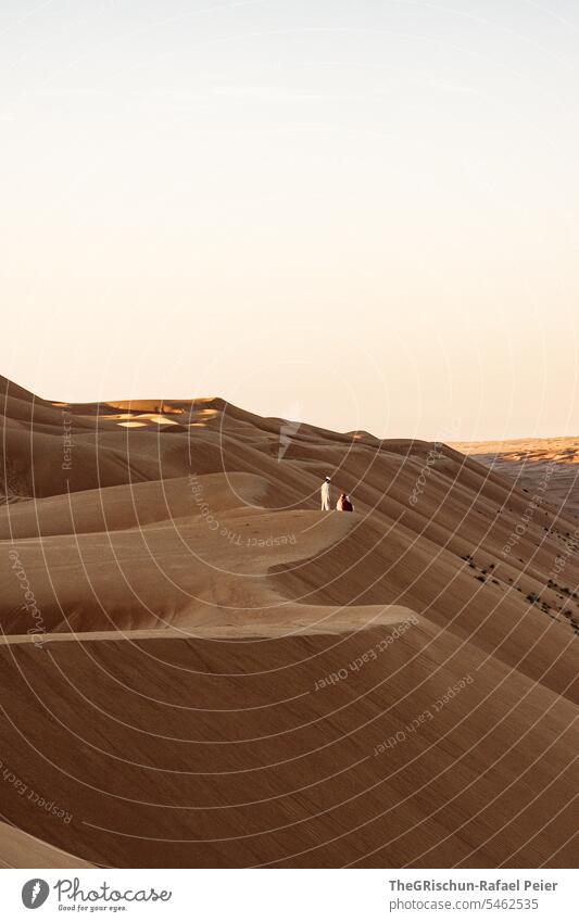 Junger Mann steht auf Dünenrand und beobachte den Sonnenuntergang Sand Außenaufnahme Farbfoto Natur Tourismus Wahiba Sands Oman omanische Wüste Landschaft