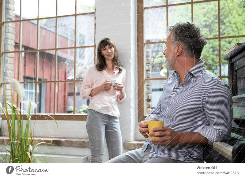 Reifere Paare machen zu Hause eine Pause, unterhalten sich und trinken Kaffee Pärchen Partnerschaft sprechen reden Zuhause daheim Pause machen Getränk Getraenk
