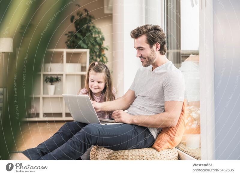 Junger Mann und kleines Mädchen surfen zusammen im Netz Websurfen Im Net surfen Surfen Wohnzimmer Wohnraum Wohnung Wohnen Wohnräume Wohnungen Erreichbarkeit