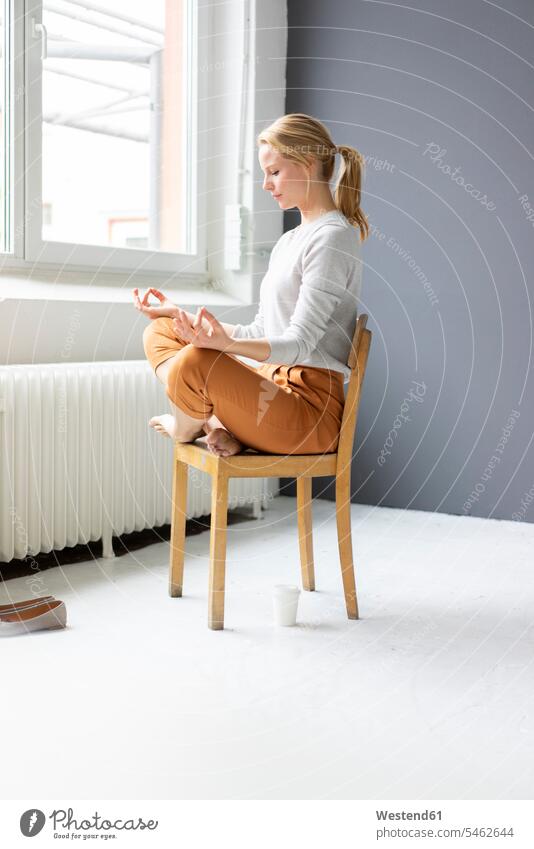 Junge Frau, die im Büro auf einem Stuhl sitzt und Yoga praktiziert Job Berufe Berufstätigkeit Beschäftigung Jobs geschäftlich Geschäftsleben Geschäftswelt
