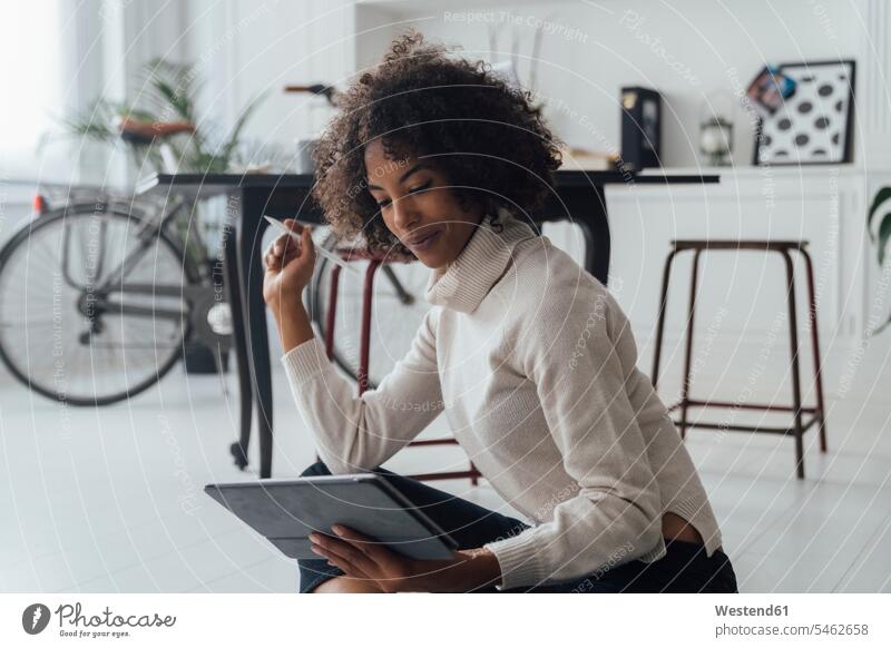 Disigner sitzt auf dem Boden ihres Heimbüros und benutzt ein digitales Tablet Spanien Tablet Computer Tablet-PC Tablet PC iPad Tablet-Computer Freiberufler