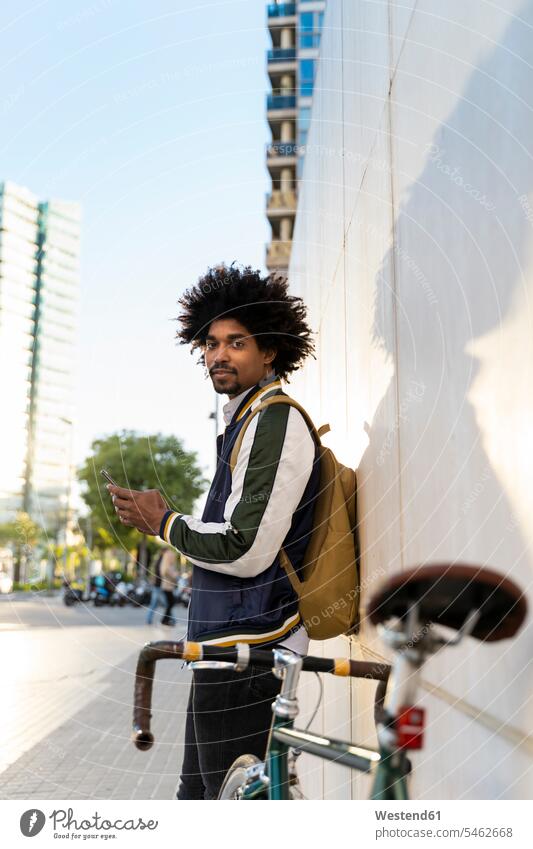 Lässiger Geschäftsmann mit Fahrrad und Mobiltelefon in der Stadt, Barcelona, Spanien geschäftlich Geschäftsleben Geschäftswelt Geschäftsperson Geschäftspersonen