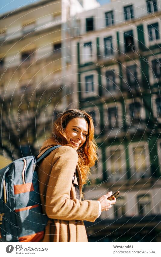 Porträt einer glücklichen jungen Frau mit Rucksack in der Stadt, Lissabon, Portugal Leute Menschen People Person Personen Alleinstehende Alleinstehender Singles