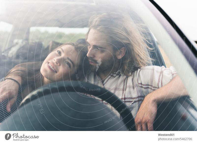 Zärtliches junges Paar in einem Auto Pärchen Paare Partnerschaft Wagen PKWs Automobil Autos Zuneigung Mensch Menschen Leute People Personen Kraftfahrzeug