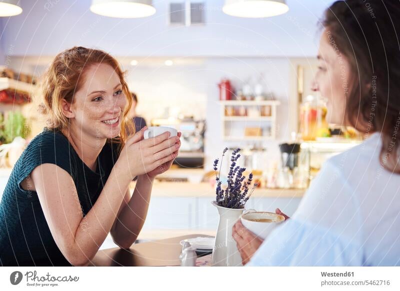 Zwei Frauen unterhalten sich und trinken Kaffee im Café Freundinnen weiblich Cafe Kaffeehaus Bistro Cafes Kaffeehäuser sprechen reden Freunde Freundschaft