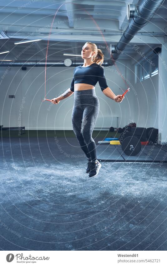Athletische Frau springt mit Springseil in Turnhalle Workout Fitnessstudio Fitnessclubs Fitnessstudios seilspringen hüpft Seil seilspringend Seil springen