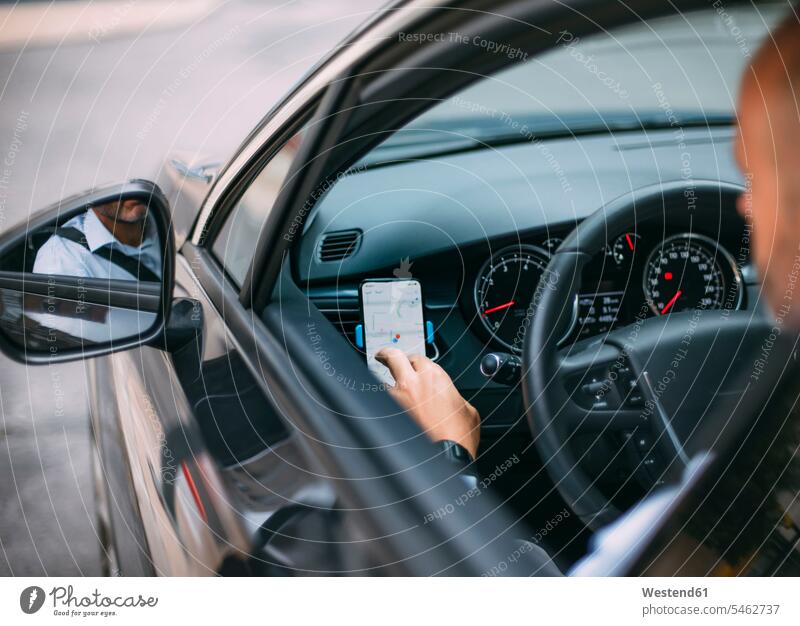 Geschäftsmann, der ein Fahrzeug fährt und ein Smartphone benutzt Leute Menschen People Person Personen Europäisch Kaukasier kaukasisch 1 Ein ein Mensch eine