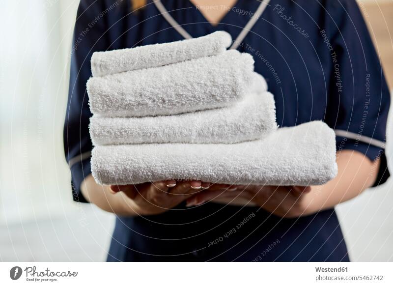 Nahaufnahme eines Zimmermädchens mit Handtüchern im Hotelzimmer Farbaufnahme Farbe Farbfoto Farbphoto Innenaufnahme Innenaufnahmen innen drinnen Millennials