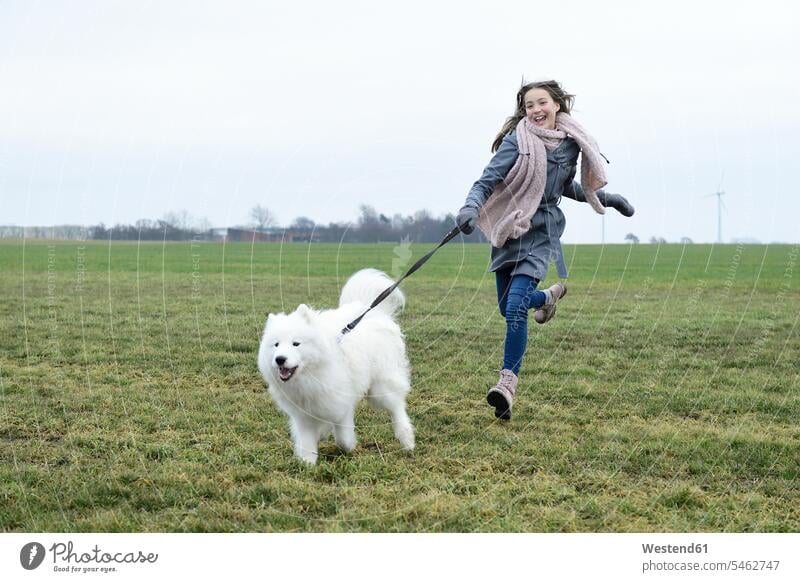 Lachendes Mädchen läuft auf einer Wiese mit ihrem Hund lachen weiblich laufen rennen Wiesen Hunde positiv Emotion Gefühl Empfindung Emotionen Gefühle fühlen