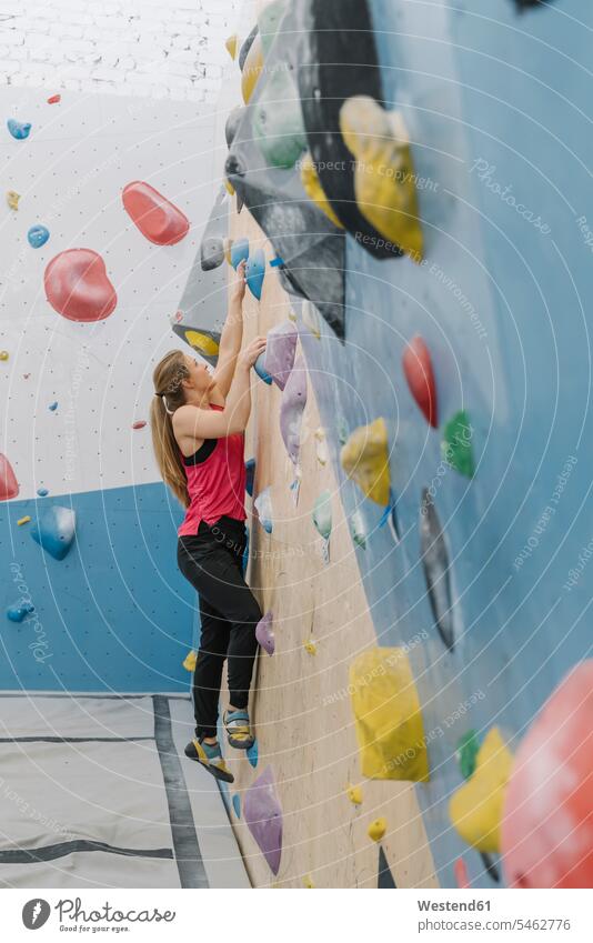 Junge Frau beim Klettern Bouldern an Wand in Kletterhalle Stock