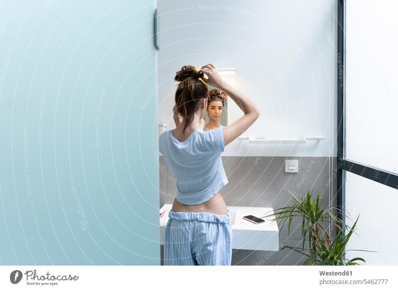 Rückansicht einer jungen Frau im Badezimmer Telekommunikation telefonieren Handies Handys Mobiltelefon Mobiltelefone erheben früh Frühe Morgen stehend steht