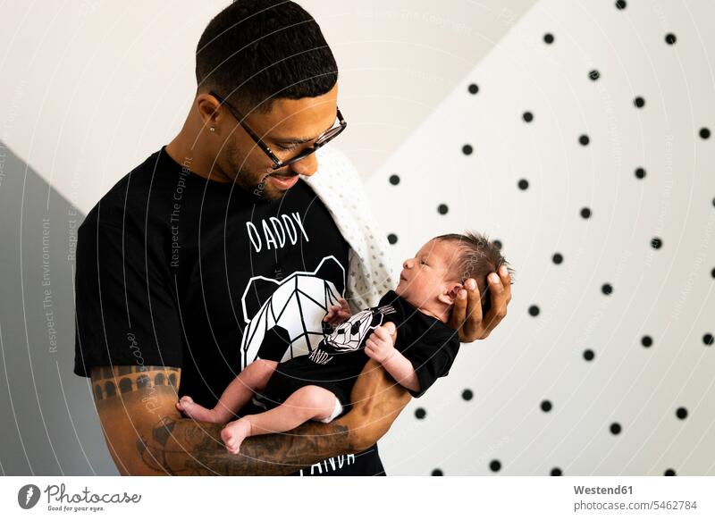 Vater hält sein neugeborenes Baby multikulturell Vaterschaft Verantwortung tätowiert T-Shirt T-Shirts Punkte gepunktet Spanien Familie mit einem Kind