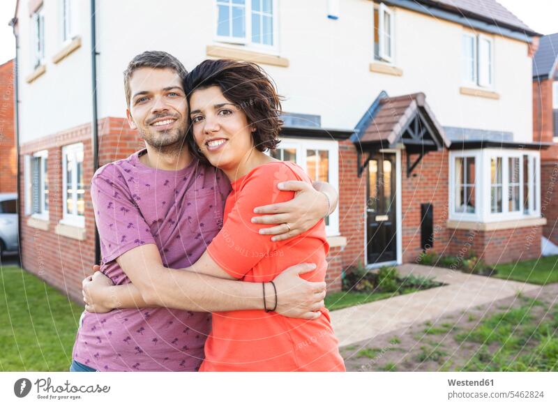 Porträt eines glücklichen Paares, das sich vor seinem neuen Zuhause umarmt Leute Menschen People Person Personen Europäisch Kaukasier kaukasisch 2 2 Menschen