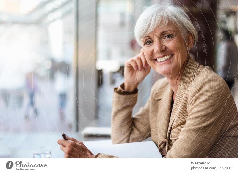 Porträt einer lächelnden älteren Geschäftsfrau mit Notizbuch in einem Café Geschäftsfrauen Businesswomen Businessfrauen Businesswoman Frau weiblich Frauen