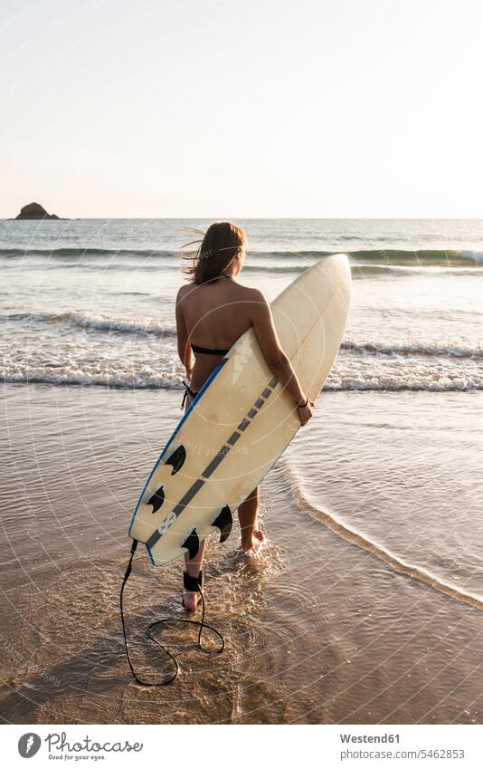 Junge Frau geht im Wasser, trägt Surfbrett Surfbretter surfboard surfboards Meer Meere Strand Beach Straende Strände Beaches tragen transportieren gehen gehend