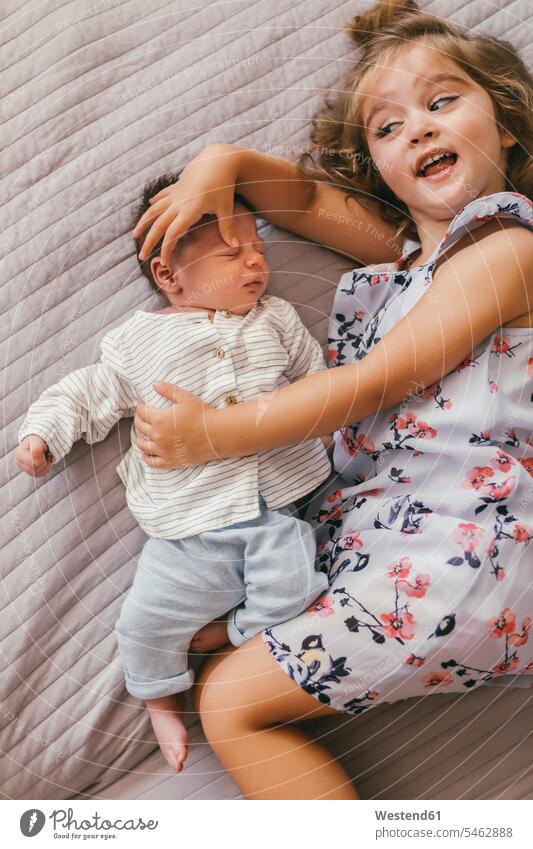 Playful Mädchen auf der Decke liegend kuscheln mit ihrem kleinen Bruder verspielt spielerisch weiblich liegt schmusen knuddeln Baby Babies Babys Säuglinge Kind