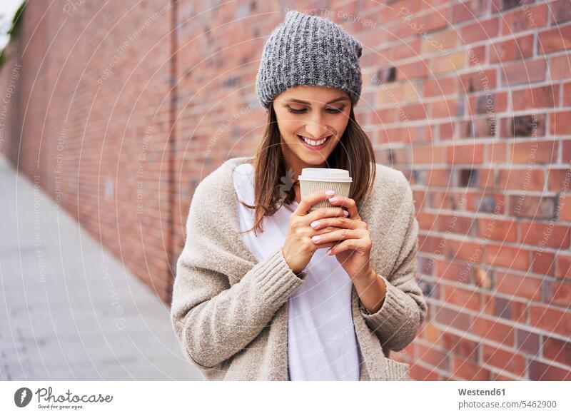 Glückliche Frau mit Kaffee zum Mitnehmen Coffee to go zum mitnehmen glücklich glücklich sein glücklichsein weiblich Frauen Getränk Getraenk Getränke Getraenke
