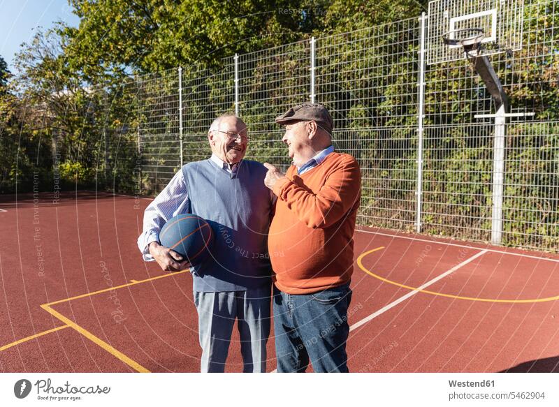 Zwei fitte Senioren haben Spaß auf einem Basketballfeld spielen sportlich sprechen reden Ball Bälle Beste Freunde Bester Freund lachen Sport Freundschaft