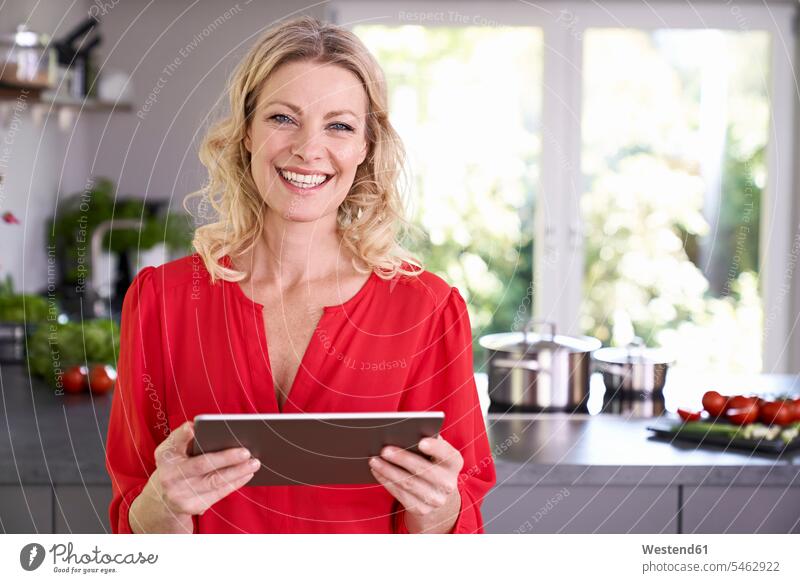 Porträt einer lächelnden Frau, die eine Tablette in der Küche hält Tablet Computer Tablet-PC Tablet PC iPad Tablet-Computer halten Küchen Portrait Porträts