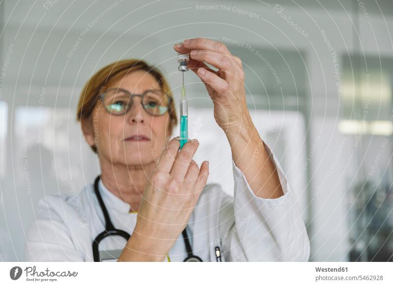 Arzt bereitet einen Impfstoff für den Patienten vor Job Berufe Berufstätigkeit Beschäftigung Jobs Glasscheiben Gesundheit Gesundheitswesen medizinisch