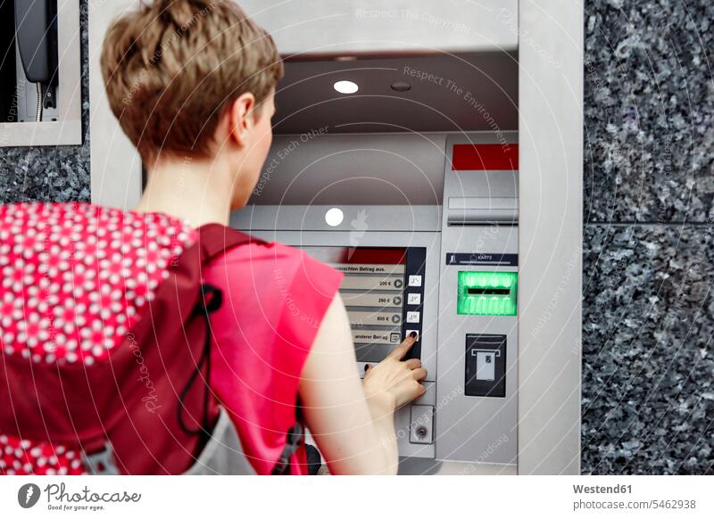 Rückansicht einer Frau, die einen Geldautomaten benutzt Bancomaten Geldausgabeautomat Bankomaten Geldausgabeautomaten Bankautomat Bankautomaten benutzen