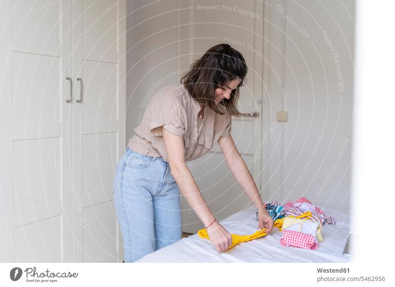 Junge Frau legt Kleider aufs Bett Leute Menschen People Person Personen Europäisch Kaukasier kaukasisch 1 Ein ein Mensch eine nur eine Person single erwachsen