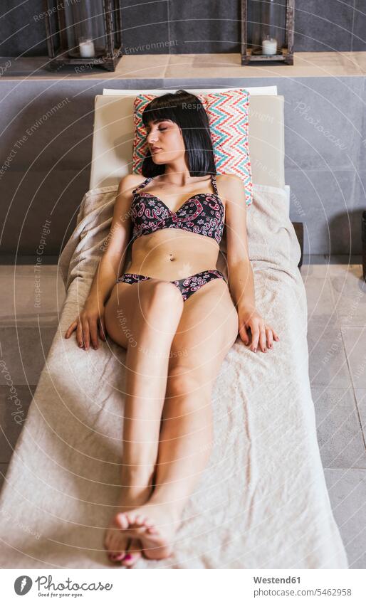 Junge Frau entspannt sich in einem Spa Badebekleidung Bikinis Liegen entspannen relaxen schlafend entspanntheit relaxt geniessen Genuss liegend liegt Muße