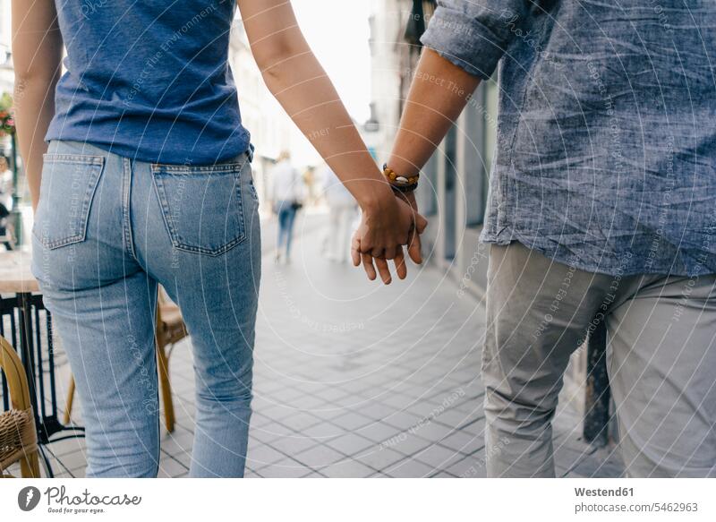 Niederlande, Maastricht, Nahaufnahme eines jungen Paares, das Hand in Hand durch die Stadt geht gehen gehend staedtisch städtisch Pärchen Partnerschaft