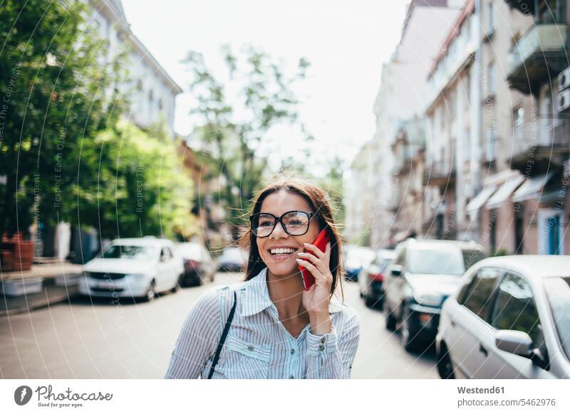 Glückliche junge Geschäftsfrau im Gespräch auf Handy auf der Straße Leute Menschen People Person Personen 1 Ein ein Mensch eine nur eine Person single erwachsen