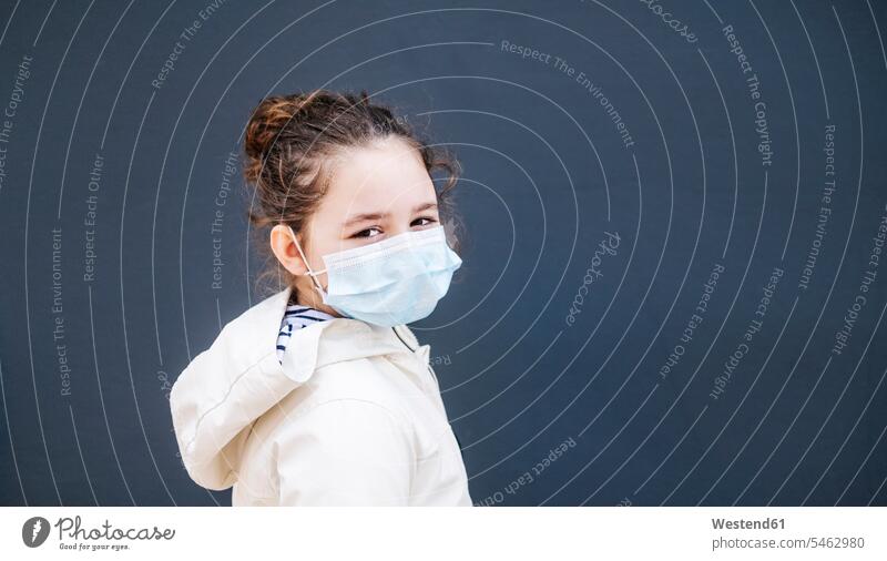 Mädchen mit chirurgischer Maske vor dunkelblauem Hintergrund weiss weiße weißer weißes Muße Gesund geschützt schützen Absicherung Waende Wände außen draußen