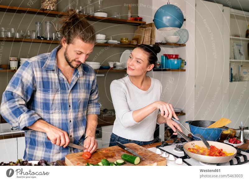 Junges Paar bei der gemeinsamen Zubereitung von Essen, Verkostung von Spaghetti Gemeinsam Zusammen Miteinander Küche kochen zubereiten Essen zubereiten Pärchen