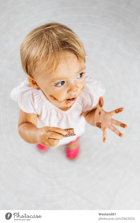 Porträt eines kleinen Mädchens, das einen Schokoladenkeks isst blond blonde Haare blondes Haar Schokoladenkekse Schokokeks Schokokekse Portrait Porträts