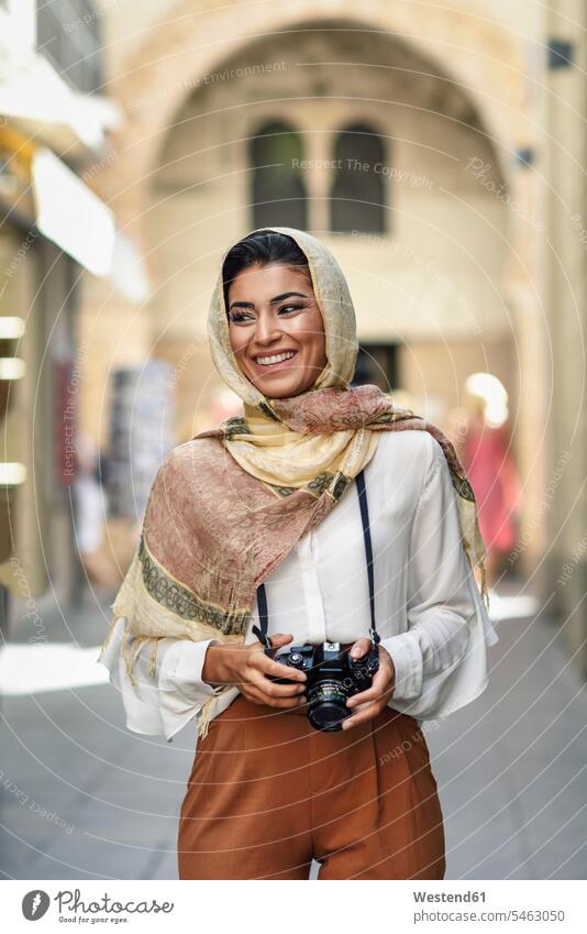 Spanien, Granada, junge arabische Touristin Frau trägt Hijab, mit Kamera während der Besichtigung in der Stadt Kopftuch Kopftücher Hidschab weiblich Frauen