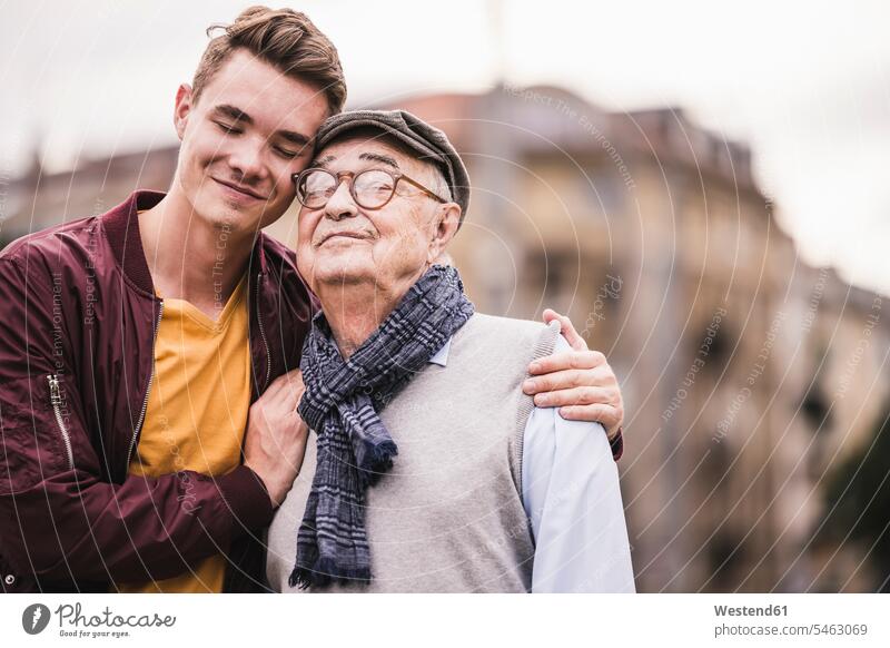 Porträt eines glücklichen älteren Mannes Kopf an Kopf mit seinem erwachsenen Enkel Leute Menschen People Person Personen Europäisch Kaukasier kaukasisch 2