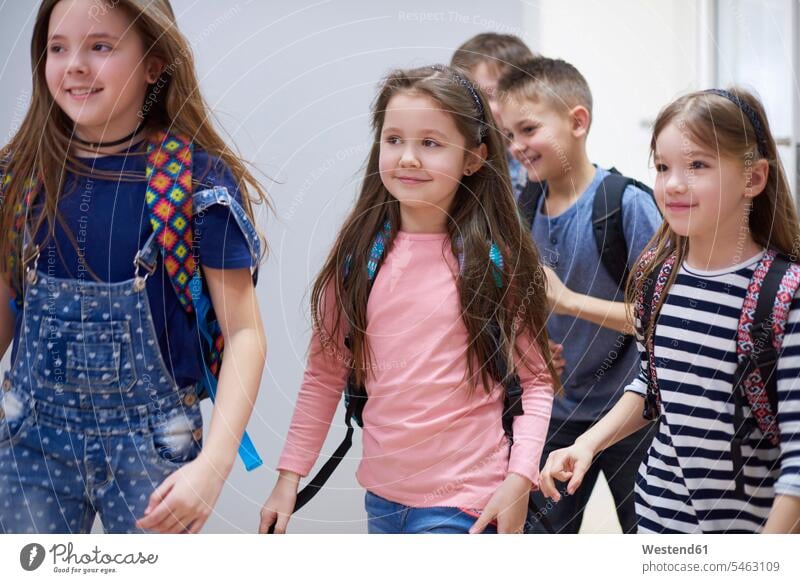 Lächelnde Schüler auf dem Flur beim Verlassen der Schule lächeln Schulen verlassen Gang Hausflur Hausflure Korridor Flure Schulkind Schueler Schulkinder Bildung