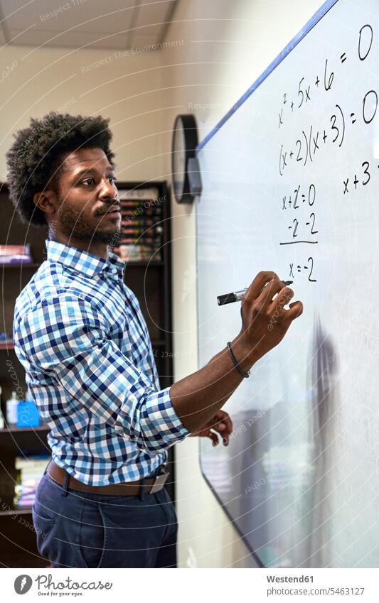 Mathelehrer schreibt eine Formel an eine Tafel Job Berufe Berufstätigkeit Beschäftigung Jobs Schultafel Schultafeln Wandtafeln Hemden Stifte ausrechnen