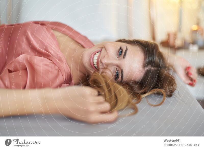 Porträt einer glücklichen jungen Frau im Morgenmantel im Bett liegend Betten weiblich Frauen liegt Glück glücklich sein glücklichsein Portrait Porträts