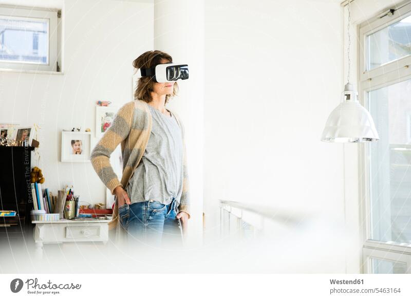 Frau trägt VR-Brille zu Hause Zuhause daheim Virtuelle Realität Virtuelle Realitaet Brillen weiblich Frauen Erwachsener erwachsen Mensch Menschen Leute People
