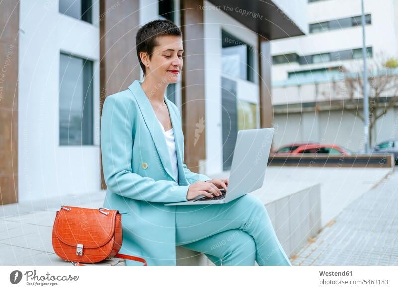 Frau im Anzug Jacke mit Laptop im Freien weiblich Frauen Bank Sitzbänke Bänke Sitzbank Notebook Laptops Notebooks benutzen Erwachsener erwachsen Mensch Menschen