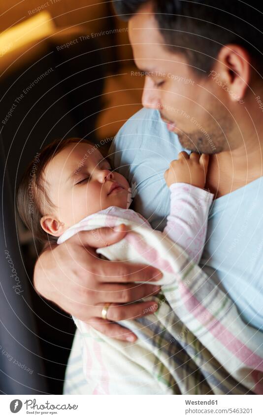 Zärtlicher Vater schaut auf das schlafende Mädchen in seinen Armen Tochter Töchter Papas Väter Vati Vatis Papis Zuneigung Baby Babies Babys Säuglinge Kind