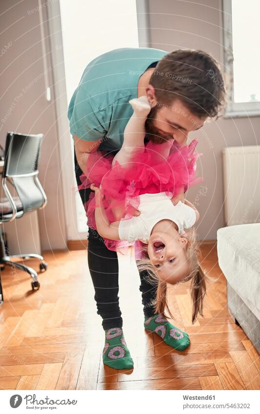 Vater und Tochter spielen zu Hause Roecke Röcke begeistert Enthusiasmus enthusiastisch Überschwang Überschwenglichkeit freuen pinkfarben rosa daheim Muße