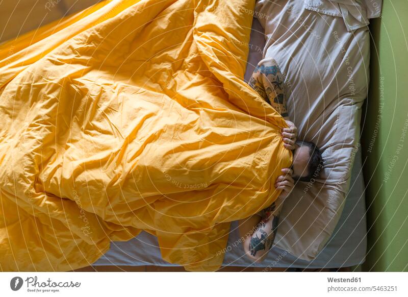 Tätowierter Mann im Bett liegend, Decke über dem Gesicht Leute Menschen People Person Personen Europäisch Kaukasier kaukasisch erwachsen Erwachsene Männer