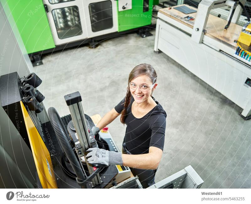 Junge Frau arbeitet an einer Maschine Arbeitsplatz Arbeitsstätte Arbeitstelle Zufriedenheit zufrieden Schutzhandschuh Schutzhandschuhe eine Person single 1