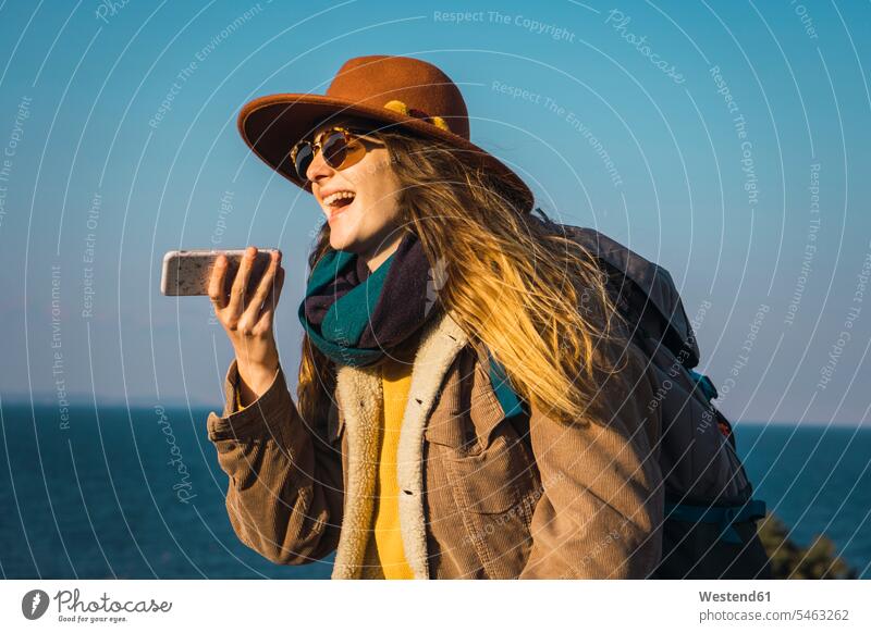 Italien, Sardinien, lachende Frau auf einer Wanderung mit Handy in der Hand wandern Wandertour weiblich Frauen Mobiltelefon Handies Handys Mobiltelefone Ausflug