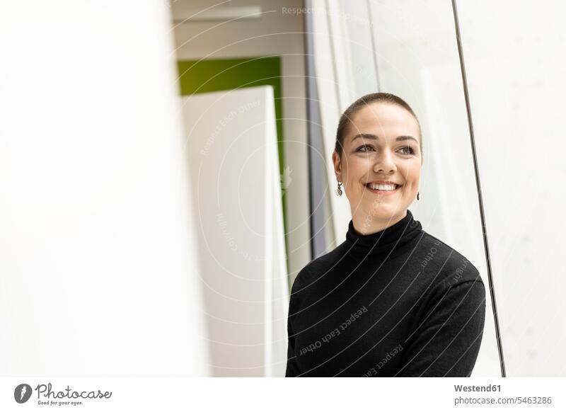 Porträt einer lächelnden jungen Frau am Fenster im Büro Job Berufe Berufstätigkeit Beschäftigung Jobs Leute Menschen People Person Personen kurzes Haar