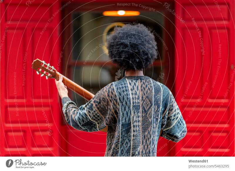 Junger Mann spielt Gitarre, während er vor einem Gebäude steht Farbaufnahme Farbe Farbfoto Farbphoto Spanien Freizeitbeschäftigung Muße Zeit Zeit haben